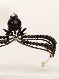 Macro detail of French vintage bridal crown featuring black gems and gold alloy plating