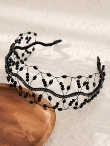 Vue macro d'un serre-tête en résille de perles de cristal noir fait main au design baroque gothique