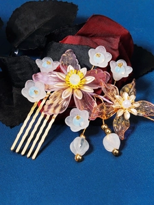 Detailed close-up of golden metal bridal hair comb with resin flowers and pearls
