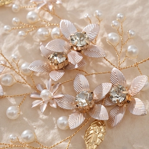 Gros plan sur l'accessoire de mariée fait main avec feuilles dorées et perles