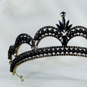 Close-up of golden bridal tiara featuring black gemstones and intricate crystal inlay
