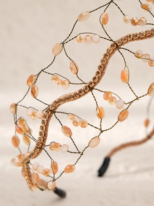 Détail macro du serre-tête baroque fait main avec perles de cristal pêche et résille
