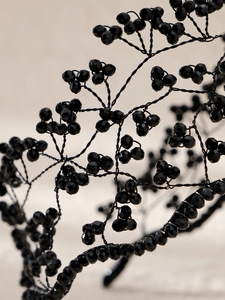 Détail macro d'un serre-tête gothique avec perles noires et structure en fils de fer