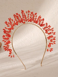 Close-up of handmade gold headband with radiant red crystal beads for bridal hair