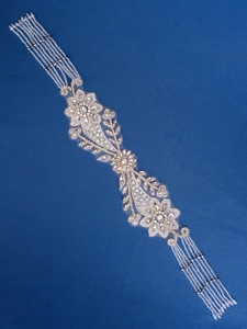 Macro detail of bridal belt with luxury silver sequins and beaded fringe on blue fabric