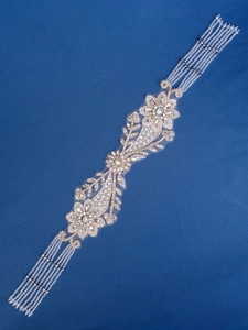 Detailed macro view of silver rhinestone flower embroidery with five-row crystal bead fringe