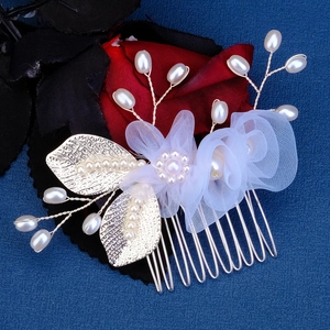 Elegant bridal hair comb with white mesh flowers, pearls and golden leaves on blue backdrop