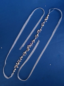 Detail of handmade bridal pearl waist chain with gold wire and translucent organza ribbon
