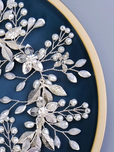 Détail de ceinture de mariée faite main avec feuilles argentées, perles et cristaux