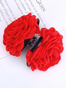 Dettaglio macro di un grande fermaglio per capelli con rosa rossa in tessuto a più strati