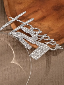 Close-up of sparkling silver rhinestone letters on a sleek fashion headband for parties