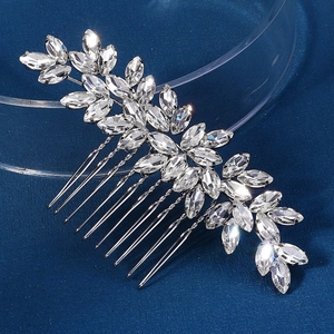 Détail d'un peigne de mariée argenté avec strass marquise sur fond en velours bleu