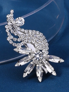 Detailed macro view of sparkling rhinestone flower brooch on navy textured background
