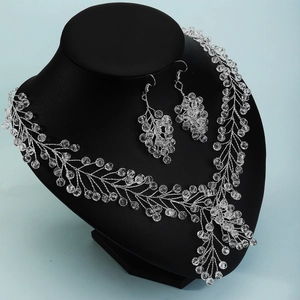 Detailed shot of handmade silver wire bridal jewelry set with crystals on a display neck