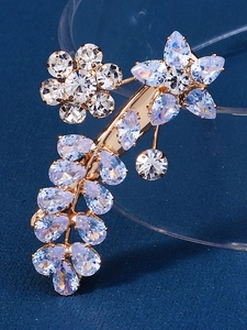 Detail macro view of luxury gold floral ear cuff with sparkling rhinestone drop crystals