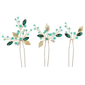 Handmade gold bridal hair pin set with green crystals and metal leaves on white background