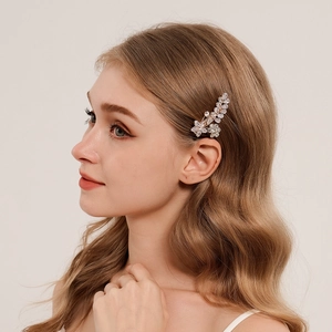 Elegant floral metal hair clip with zircons on golden wavy hair shown from side profile