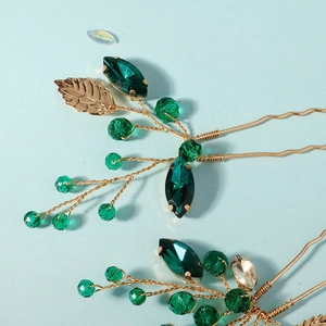 Detail of handmade green crystal bridal hair pin with golden leaves for hair styling