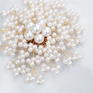 Vue détaillée d'une broche fleur en perles faite main avec fil doré sur marbre