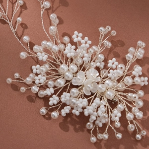Détail macro d'une broche florale en perles faite main avec perlage en fil d'argent fin