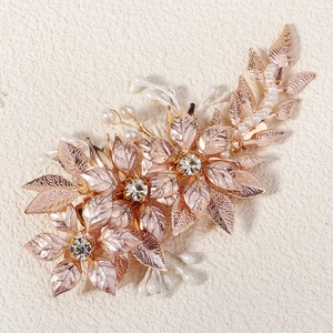 Macro d'une pince à cheveux fleur rose doré avec perles blanches et cristaux de mariée