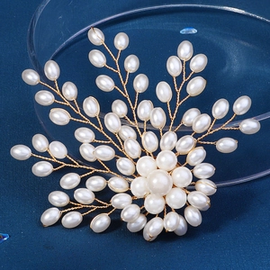 Broche fleur en perles faite main avec détails en fil d'or sur fond bleu foncé