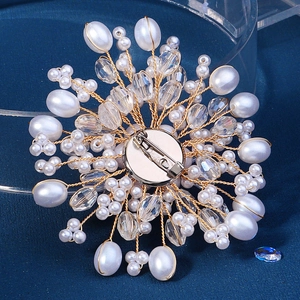 Broche fleur en perles faite main avec fil doré et épingle argentée sur fond bleu