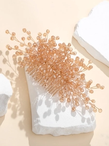 Detail showing handcrafted crystal beads woven on golden wire bridal hair comb