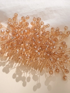 Detailed macro view of handmade golden bridal hair comb with champagne crystal beads