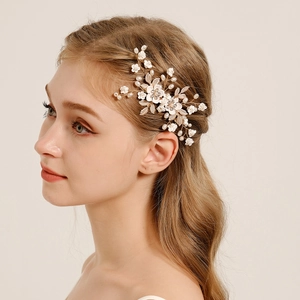 Exquisite bridal hair comb with white ceramic flowers, gold wire, and faux pearls