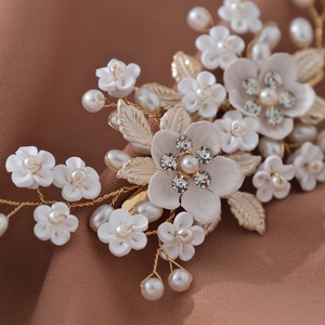 Pince à cheveux fleurie avec fleurs blanches, perles et feuilles dorées pour mariée élégante