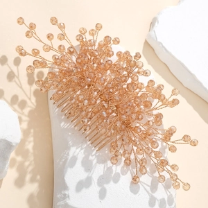 Handmade champagne crystal bridal hair comb with gold wire on a white stone background