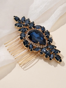 Détail d'un peigne à cheveux vintage doré avec des strass bleu marine en forme de poire