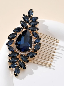 Gros plan d'un peigne à cheveux doré avec des strass bleu foncé en forme de poire