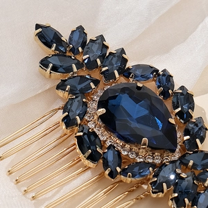 Vintage gold bridal hair comb with deep blue crystals and white rhinestones on silk background