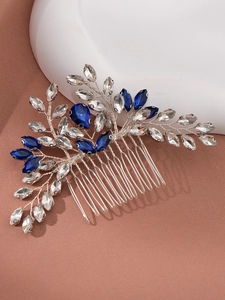 Détail d'un peigne à cheveux argenté avec strass marquise transparents et bleu marine