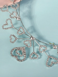 Detailed close-up of sparkling heart rhinestones on a silver metal headband for parties