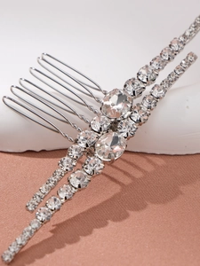 Detailed close-up of a silver-toned hair comb with glittering oval and round rhinestones