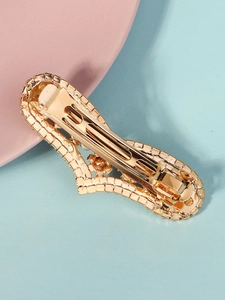 Detail view of the gold-plated rhinestone hair clip showing back spring mechanism