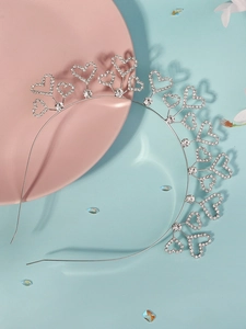 Detail of silver rhinestone heart headband with crystal accents on a pastel background