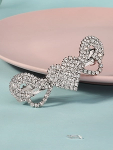 Close-up of silver rhinestone hair clip with heart and infinity symbol patterns