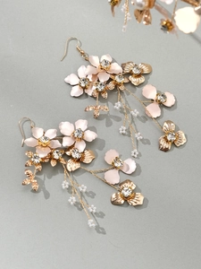 Détails des boucles d'oreilles de mariée avec pétales roses et feuilles dorées