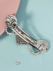 Detail of the silver-tone metal spring clip mechanism on the back of the rhinestone hairpin