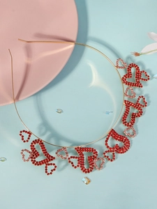 Detail of gold metal headband with sparkling red and pink rhinestone heart patterns
