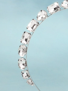 Gros plan sur un serre-tête argenté avec des strass en cristal de formes variées
