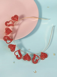 Detailed macro view of thin golden headband with red rhinestone heart elements on side