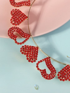 Detail of gold headband featuring red rhinestones in LOVE letters and heart shapes