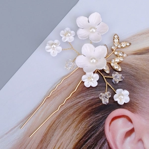 Vue détaillée d'une épingle à cheveux en U avec fleurs blanches et feuilles en cristal doré