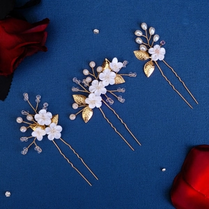 Detailed close-up of handmade bridal hair pins with clay flowers, pearls and crystals