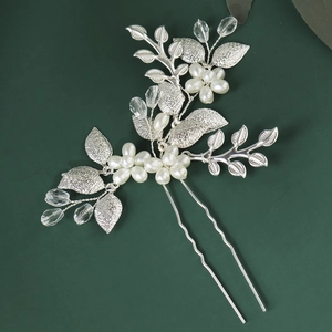 Vue macro détaillée d'une fleur en perles blanches et feuilles argentées sur épingle à cheveux